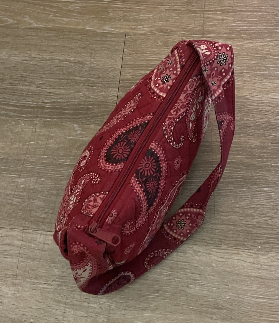 A small red Vera Bradley handbag with a shoulder strap